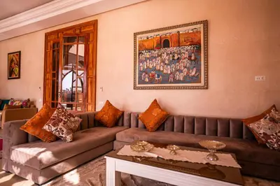 a living room with a couch and a painting on the wall at Palais Menzah & SPA in Marrakech