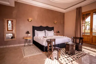 a bedroom with a bed and two tables and a mirror at Palais Menzah & SPA in Marrakech