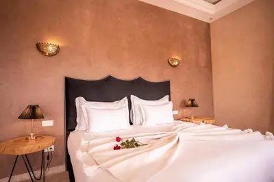 a bedroom with a large white bed with flowers on it at Palais Menzah & SPA in Marrakech