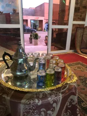 a tray of glass jars and a tea kettle on a table at Hotel kasbah telouet in Telouet