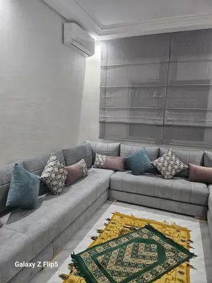 a living room with a gray couch with pillows at Appartement bassatine in Fès