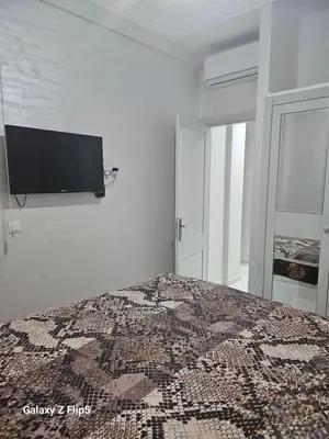 a bedroom with a bed with a tv on the wall at Appartement bassatine in Fès
