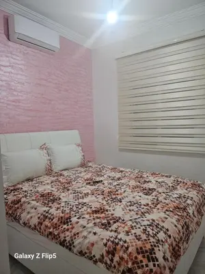 a bedroom with a bed with a comforter and a window at Appartement bassatine in Fès