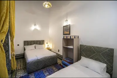 a room with two beds in a room with two lamps at Dar Fes Flower in Fès