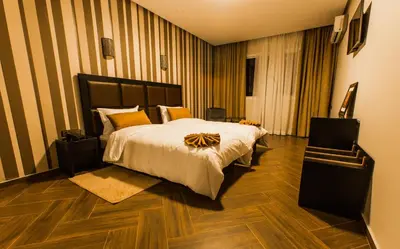 a hotel room with a bed and a chair at Hotel Swani in Meknès