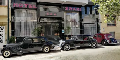 two old cars parked in front of a hotel at Hotel Swani in Meknès