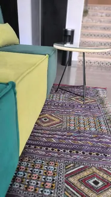 a room with a couch and a table on a rug at Hotel Swani in Meknès