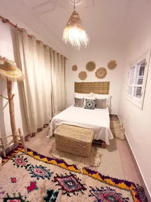 a bedroom with a bed and a chandelier at Ferme d'hôtes Pouvoir des Plantes in Ourika