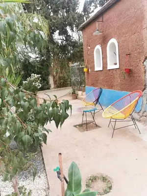 a patio with two chairs and a building at Ferme d'hôtes Pouvoir des Plantes in Ourika