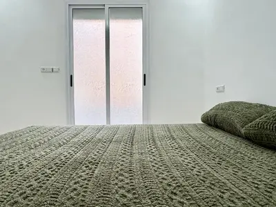 a bedroom with a bed and a large glass door at Menzeh saiss appartement in Fès
