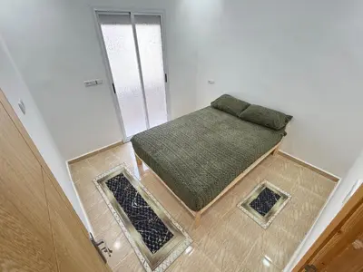 a small bedroom with a green bed in a room at Menzeh saiss appartement in Fès