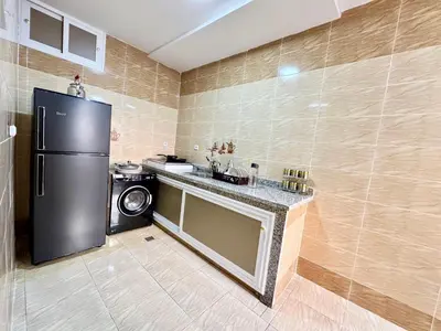 a kitchen with a black refrigerator and a microwave at Menzeh saiss appartement in Fès