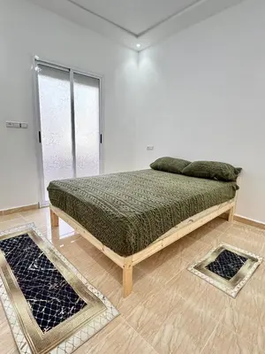 a bedroom with a bed in a white room at Menzeh saiss appartement in Fès