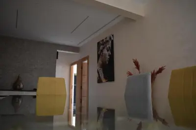 a living room with yellow chairs and a painting on the wall at Bloemenhuis 2 - Centre-ville Fez in Fès