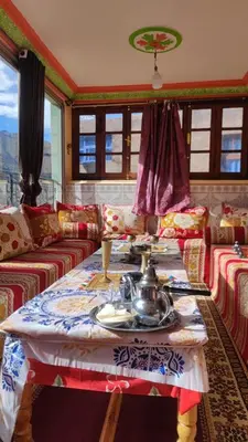 a living room with a table and a couch at Dar agzwal in Tacheddirt