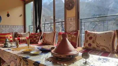 a room with a table with a view of the mountains at Dar agzwal in Tacheddirt