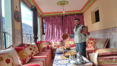 a man standing in a living room with a couch at Dar agzwal in Tacheddirt