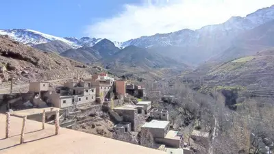 a village in a valley with mountains in the background at Dar agzwal in Tacheddirt