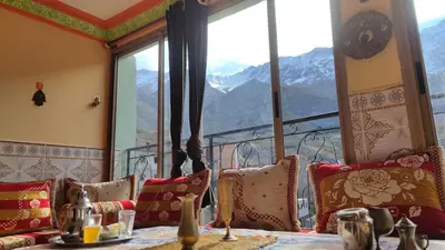 a room with a table with pillows and a window at Dar agzwal in Tacheddirt