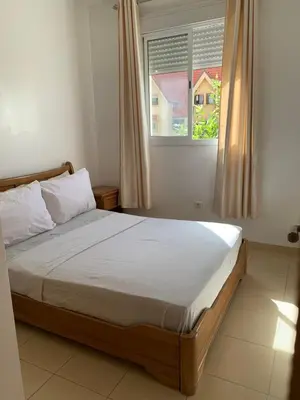 a bedroom with a large bed with a window at Lolla home in Ifrane