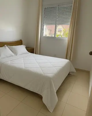 a bedroom with a white bed and a window at Lolla home in Ifrane