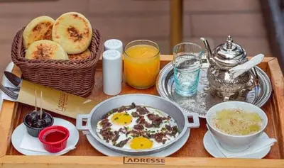 a breakfast tray with eggs and bread on a table at Lolla home in Ifrane