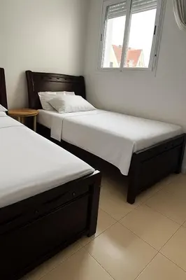 two twin beds in a room with a window at Lolla home in Ifrane