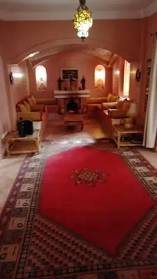 a living room with a red rug on the floor at John's Place in Chrabli