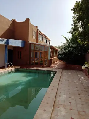 a house with a swimming pool in front of it at John's Place in Chrabli
