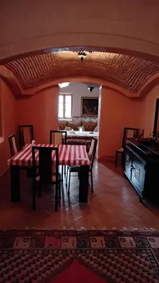 a dining room with a table and chairs in a room at John's Place in Chrabli
