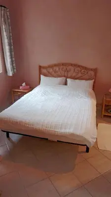 a bed with white sheets and pillows in a bedroom at John's Place in Chrabli