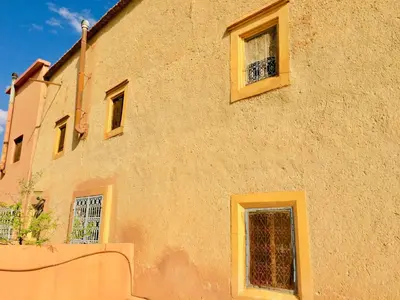 a building with two windows on the side of it at Kasbah Alami in Kalaat MGouna