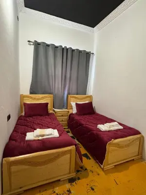 two beds in a room with red sheets at Moorish Cabana in Fès