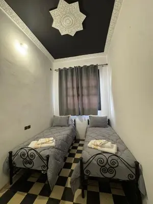 a bedroom with two beds and a ceiling with a star at Moorish Cabana in Fès