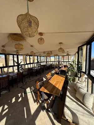 a restaurant with a table and chairs and windows at Moorish Cabana in Fès
