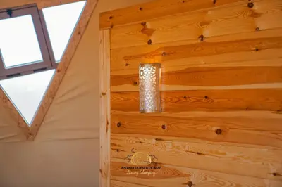 a light fixture on a wooden wall in a room at Antares Desert Camp in Merzouga