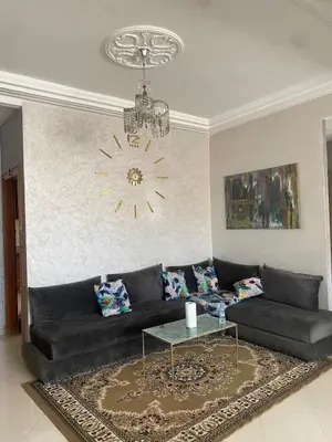 a living room with a black couch and a chandelier at Luxury Apartment Meknes in Meknès