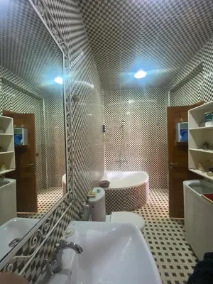 a bathroom with a tub and a sink and a mirror at Luxury Apartment Meknes in Meknès