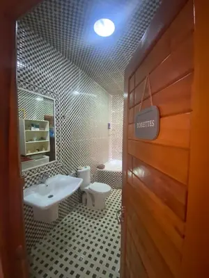 a bathroom with a sink and a toilet and a door at Luxury Apartment Meknes in Meknès