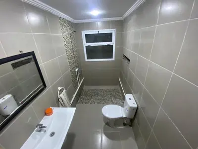 a bathroom with a toilet and a sink and a mirror at Villa Palm Star - A Peaceful Retreat with AC, WiFi & Private Parking , Arfoud in Erfoud