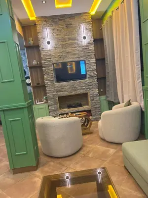 a living room with two chairs and a fireplace at Vintage Green House in Fès