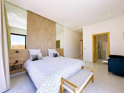 a bedroom with a large bed and a large window at villa Elyssa !Confort & modern avec Piscine privée in Marrakech