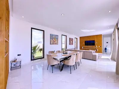 a dining room and living room with a table and chairs at villa Elyssa !Confort & modern avec Piscine privée in Marrakech