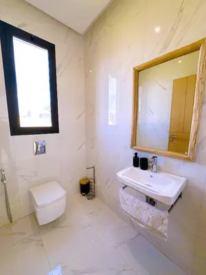a bathroom with a sink and a toilet and a mirror at villa Elyssa !Confort & modern avec Piscine privée in Marrakech