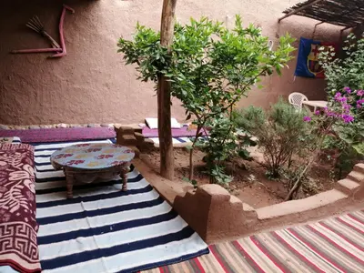 a patio with a table and a rug at Dar itran in Mhamid