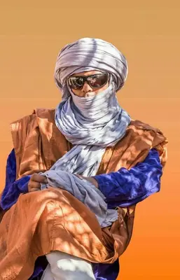 a man wearing a head scarf and sunglasses at Dar itran in Mhamid