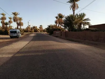 an empty road with a van parked on the side at Dar itran in Mhamid