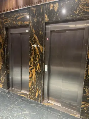 two silver elevators in a building with marble walls at Studio plein centre-ville ! in Fès