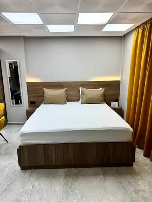 a large bed in a room with yellow curtains at Studio plein centre-ville ! in Fès