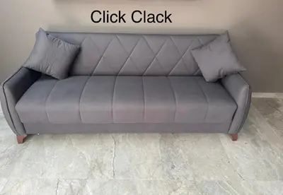 a grey couch in a room with the words click clack at Studio plein centre-ville ! in Fès